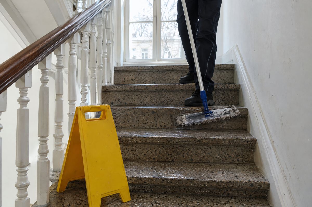 Terrazzostufen in einem hellen Hamburger Altbau-Treppenhaus werden gewischt